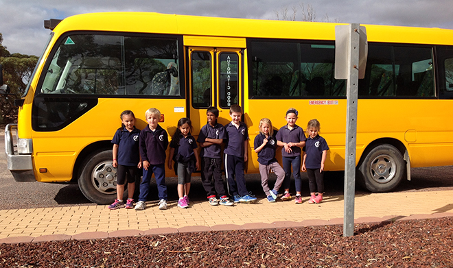 children standing by the bus